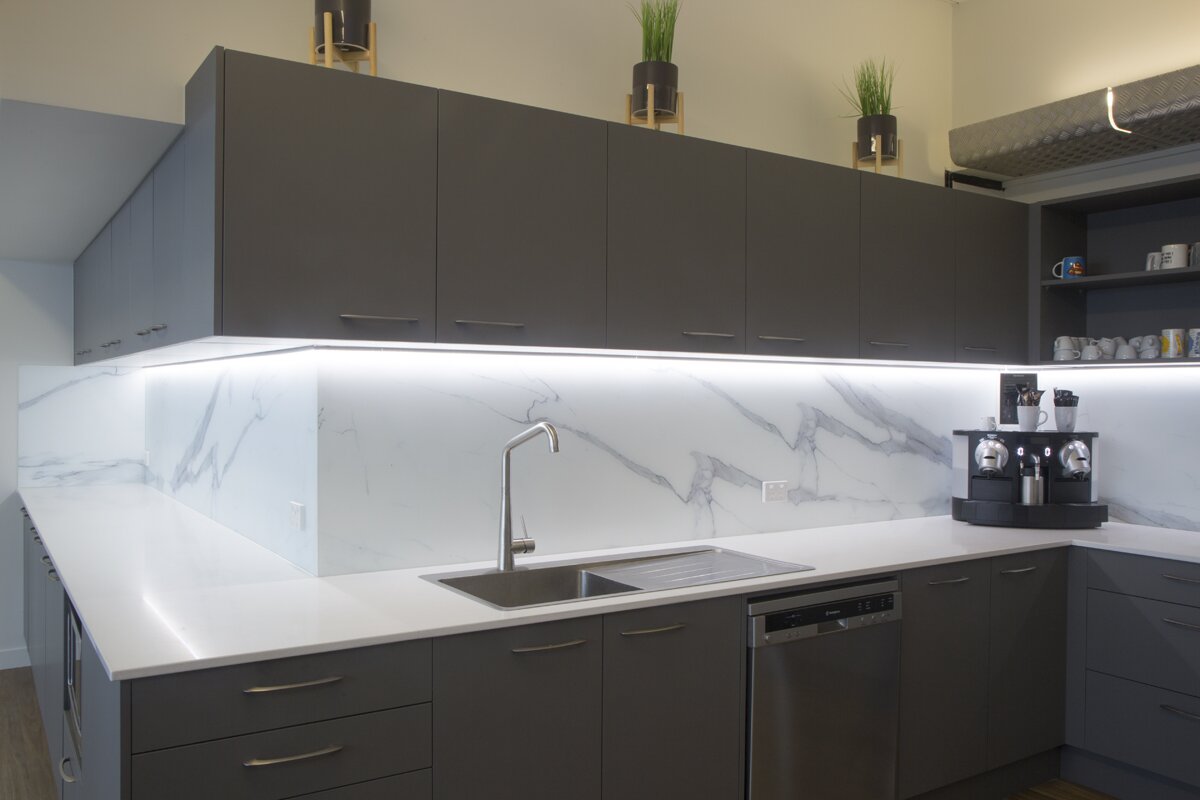 glass kitchen splashback in color white with dark gray cabinets